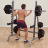 man doing back squats on body solid squat rack
