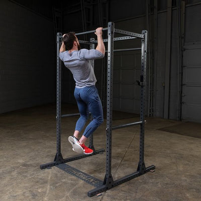 man doing pull-ups on powerline squat rack