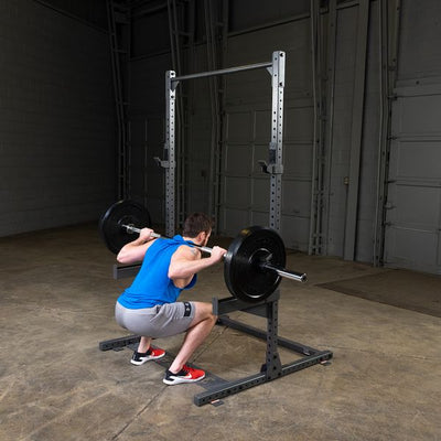 man doing squats on powerline ppr500 half rack with safety spotter arms