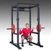 Commercial power rack SPR1000 guy doing back squats with bumper plates